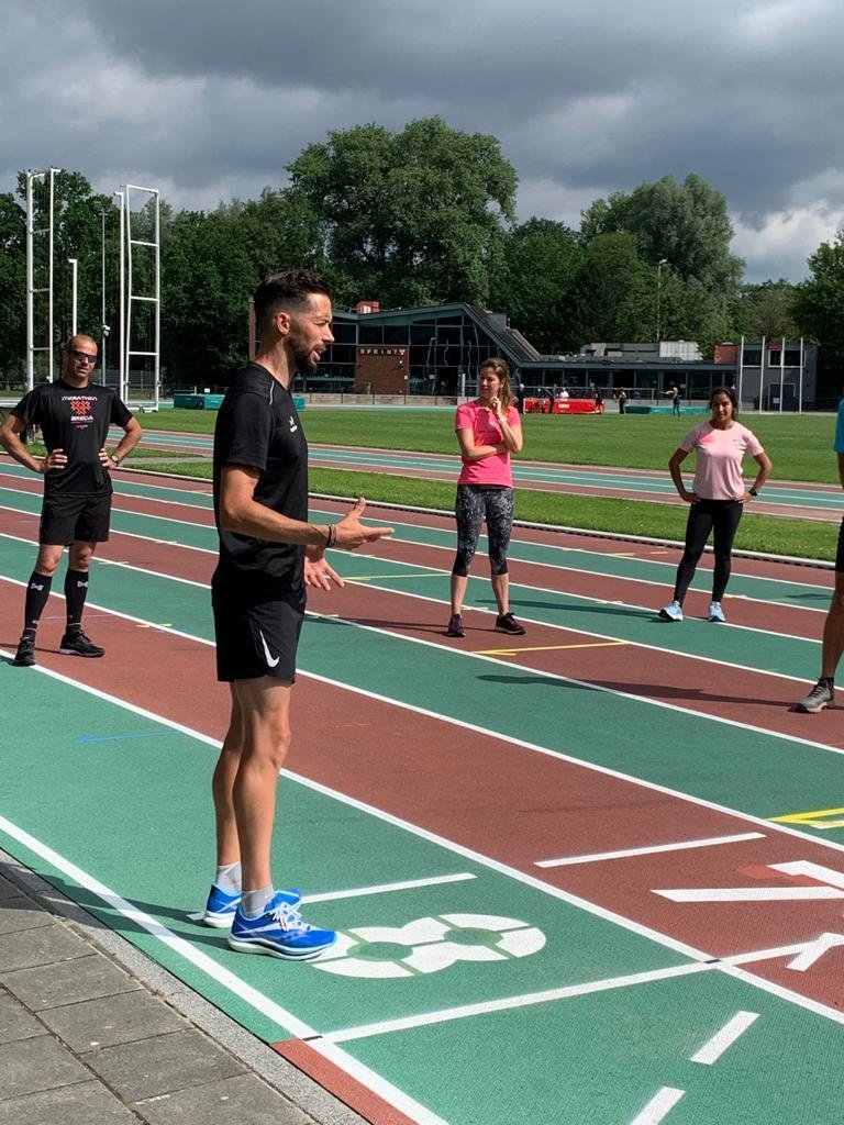 Coach briefing a group of runners on the athletics track