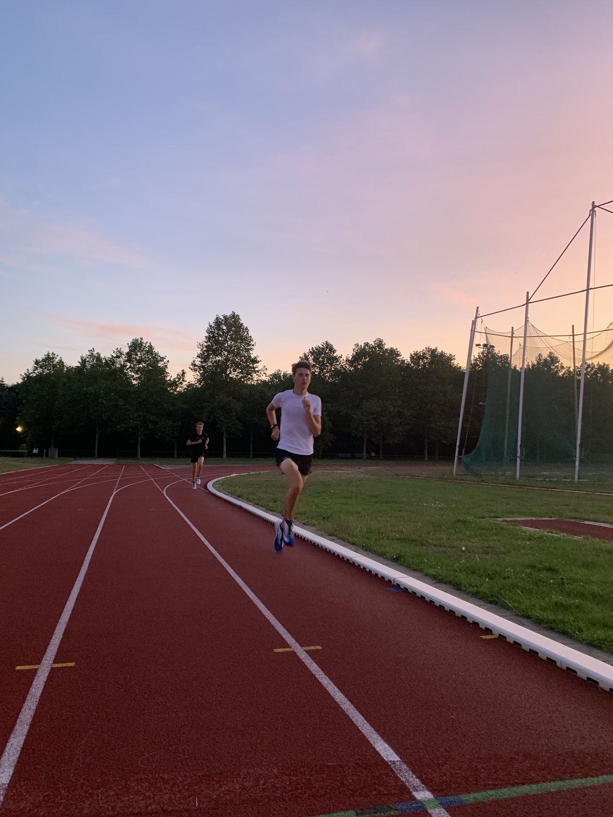 Runner on the athletics track at sunset